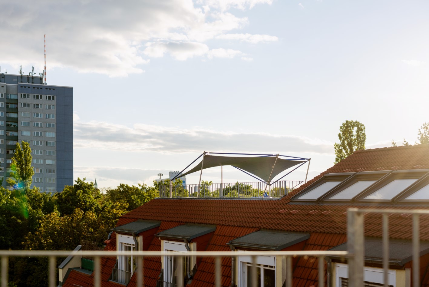 Blick auf ein Sonnensegel, welches die Dachterrasse eines Berliner Hochhauses vor Sonne und Regen schützt.