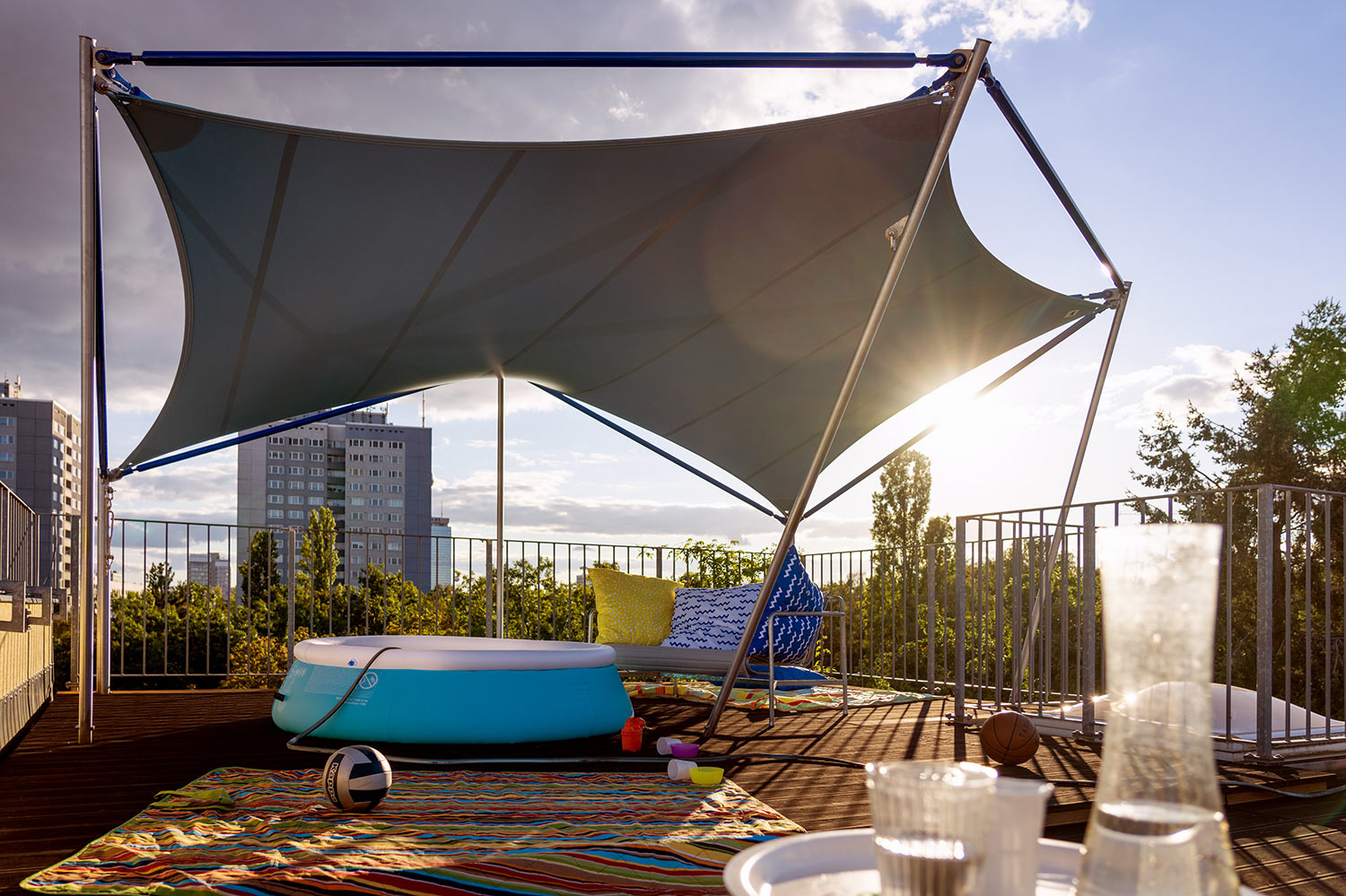 Ein Sonnensegel von STOFFDACH auf einer Berliner Dachterrasse über einem Planschbecken.